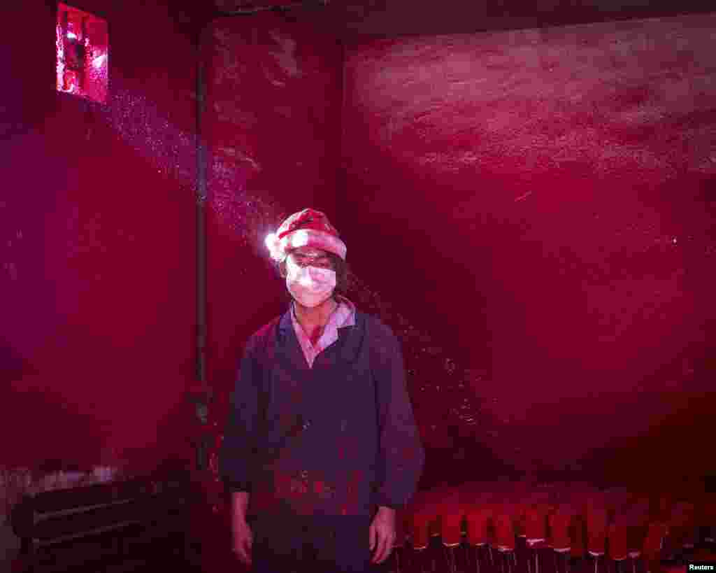 Китайский рабочий завода по производству елочных игрушек, в помещении, где сушат краску на новогодних украшениях. Фото Ронгуй Чэня (Китай) , первое место в категории &quot;Современные проблемы. Одиночные снимки&quot;.​ &nbsp;