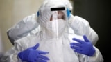 Israel - Employees of Chevra Kadisha, the main group that oversees Jewish burials in Israel, adjust their protective gear at a special centre that prepares bodies of Jews who died from the coronavirus disease (COVID-19) at a cemetery in Tel Aviv, Israel, 