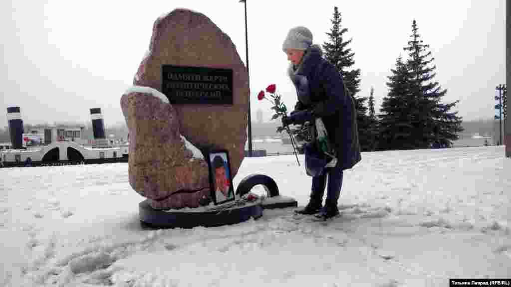 Женщина возлагает цветы к памятнику жертв политических репрессий в Красноярске