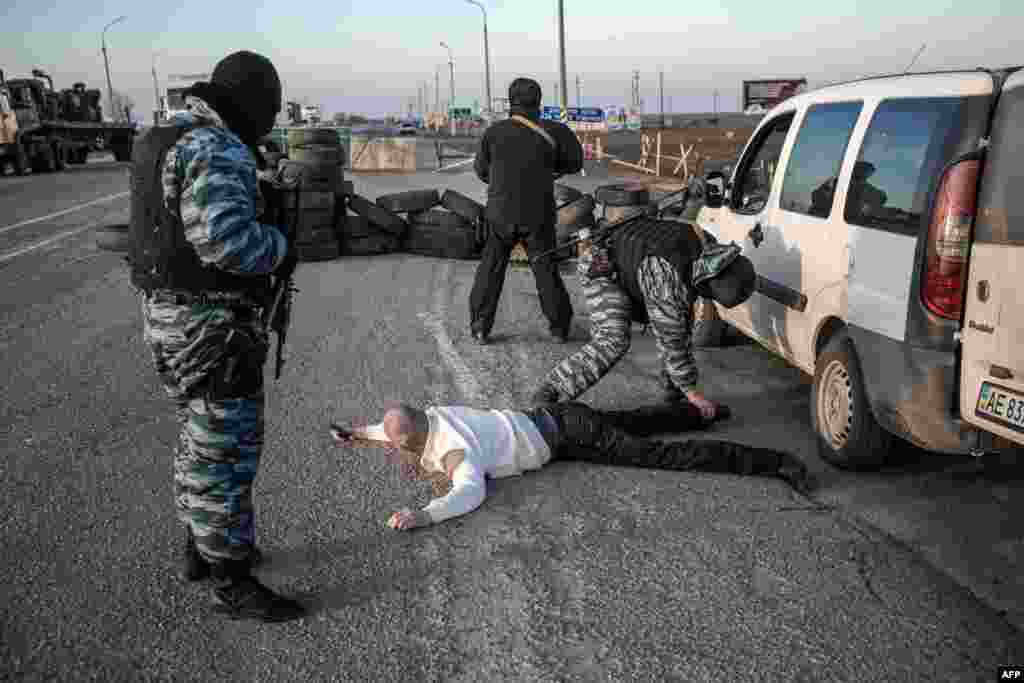 Человека обыскивают пророссийкие сепаратисты на выставленной ими же границе между материковой Украиной и полуостров невдалеке от Чонгара, 10 марта