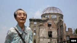 Один из выживших при бомбардировке Хиросимы на фоне Мемориала Мира (Atomic Bomb Dome), июнь 2015.