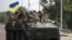 UKRAINE – Ukrainian servicemen ride atop of an armored vehicle on a road in Donetsk region, August 28, 2022 