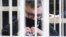 BELARUS -- Viktar Babaryka, the former head of Russia-owned Belgazprombank, gestures a heart symbol sitting in a cage in a court room in Minsk, February 17, 2021