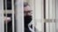 Belarus - Opposition politician and banker Viktar Babaryka, charged with corruption and money laundering, looks out from inside a defendants' cage during the opening day of his trial in Minsk, February 17, 2021