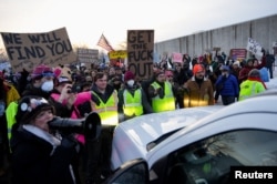 Демонстранты держат плакат "Get the fuck out!": это цитата мэра Миннеаполиса в адрес агентов ICE