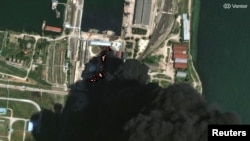 На спутниковом снимке видны огонь и дым, поднимающиеся от резервуаров с нефтью после атаки на нефтебазу в Керчи 21 июня 2026 года. Фото предоставлено Reuters