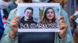 POLAND -- Protesters hold images of Belarus strongman Alyaksandr Lukashenka (L), Belarusian opposition activist Raman Pratasevich (C) and Protasevich's Russian girlfriend Sofia Sapega (R) during a demonstration of Belarusians living in Poland and Poles su