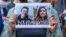POLAND -- Protesters hold images of Belarus strongman Alyaksandr Lukashenka (L), Belarusian opposition activist Raman Pratasevich (C) and Protasevich's Russian girlfriend Sofia Sapega (R) during a demonstration of Belarusians living in Poland and Poles su