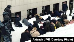 Detainees lying in the snow in Kazan