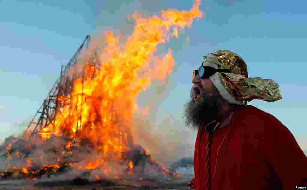 Эксцентричный российских художник Герман Виноградов сжигает масленичную пирамиду. Калужская область, Россия