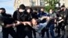 Belarus' riot police officers detain an opposition supporter during a gathering to support candidates seeking to challenge President Alyaksandr Lukashenka.