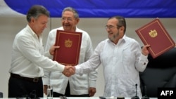 Президент Колумбии Хуан Мануэль Сантос и глава группировки FARC Тимолено Хименес ("Тимошенко") заключают соглашение о перемирии 