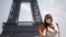 A woman wears a protective face mask at the Trocadero square near the Eiffel Tower in Paris