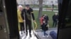 Оксана Василенко и Максим Босой поднимаются в эвакуационный автобус, Львов, 14 апреля 2026 года