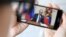 RUSSIA -- A woman watches a live broadcast of Russian President Vladimir Putin's address to the nation over the coronavirus outbreak, in Moscow on March 25, 2020