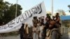AFGANISTAN -- Taliban fighters pose for a photo on Sunday, August 15, 2021, while raising a flag in Ghazni, Afghanistan.