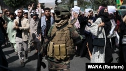 Солдат "Талибана" перед протестующими, 7 сентября 2021 года 