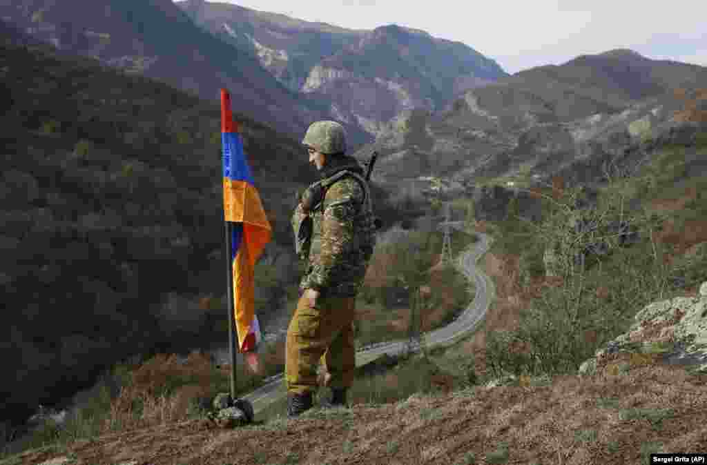 Atop a hill near the village of Charektar, not far from Azerbaijan&#39;s newly regained Kalbacar district, an ethnic Armenian soldier keeps watch next to the flag of breakaway Nagorno-Karabakh. Ethnic Armenian separatists still run Karabakah&#39;s de facto government despite the loss of large amounts of area territory to Azerbaijani forces.&nbsp;
