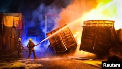 Сотрудники спасательных служб тушат пожар после российского обстрела портовой инфарструктуры Одессы 2 апреля 2026 года