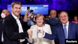 Ангела Меркель (в центре) с премьер-министром Баварии Маркусом Зёдером (слева) и лидером Христианско-демократического союза Армином Лашетом (справа) на предвыборном митинге 24 сентября 2021 года