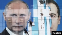 Предвыборный агитационный плакат с Владимиром Путиным и Дмитрием Медведевым на офисном здании в Краснодаре, ноябрь 2011 года. Фото: Reuters 