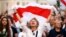 Belarus - A demonstrator reacts while holding the historical white-red-white flag of Belarus during an opposition demonstration.