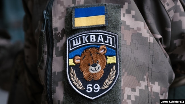 Один из вариантов эмблемы батальона Шквал на рукаве женщины-военной, бывшей заключенной