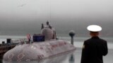 Russia -- Sailors stand on a submarine deck to honour 118 of their comrades who perished when the nuclear submarine Kursk sank. 