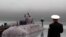 Russia -- Sailors stand on a submarine deck to honour 118 of their comrades who perished when the nuclear submarine Kursk sank. 
