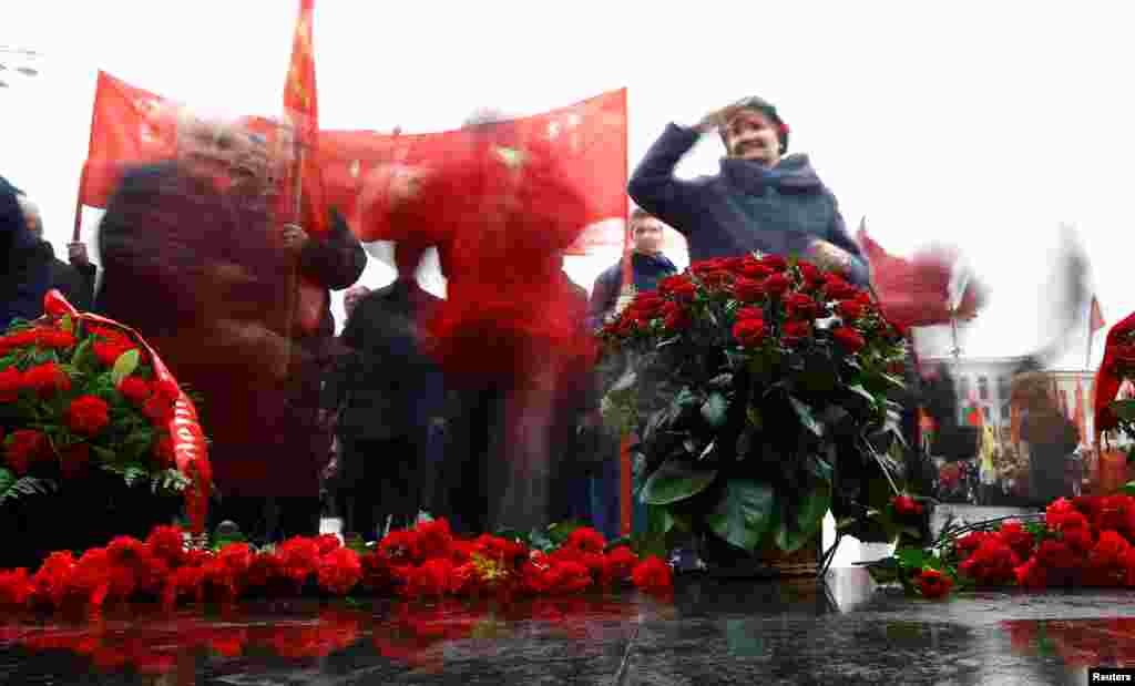 Люди возлагают цветы к памятнику Ленина на Площади независимости в Минске. 7 ноября