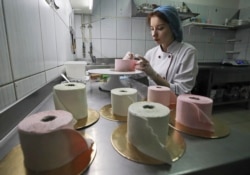 A pastry chef makes desserts in the shape of toilet paper rolls at the Cakes.by confectionery company in Minsk, Belarus to symbolize global toilet paper shortages during the COVID-19 crisis..