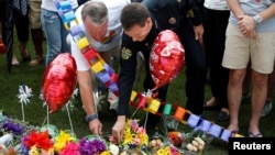 Мэр Орландо и глава полиции города возлагают цветы в память о жертвах расстрела в гей-клубе "Пульс" во Флориде 