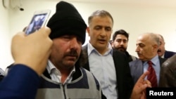 Turkey -- Zaman editor-in-chief Ekrem Dumanli (C) is escorted by plainclothes police officers as he leaves his office at the headquarters of Zaman daily newspaper in Istanbul, December 14, 2014