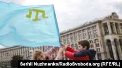 Дети держат в руках крымскотатарский флаг в центре Киева в честь Дня памяти о массовой депортации крымских татар в Центральную Азию и Сибирь в 1944 году. Украина, 18 мая (Сергей Нужненко)