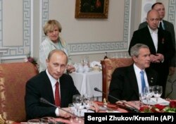 Владимир Путин с Джорджем Бушем на рабочем ужине в Санкт-Петербурге после саммита G8 19 июля 2006 г. Евгений Пригожин стоит за Джорджем Бушем.