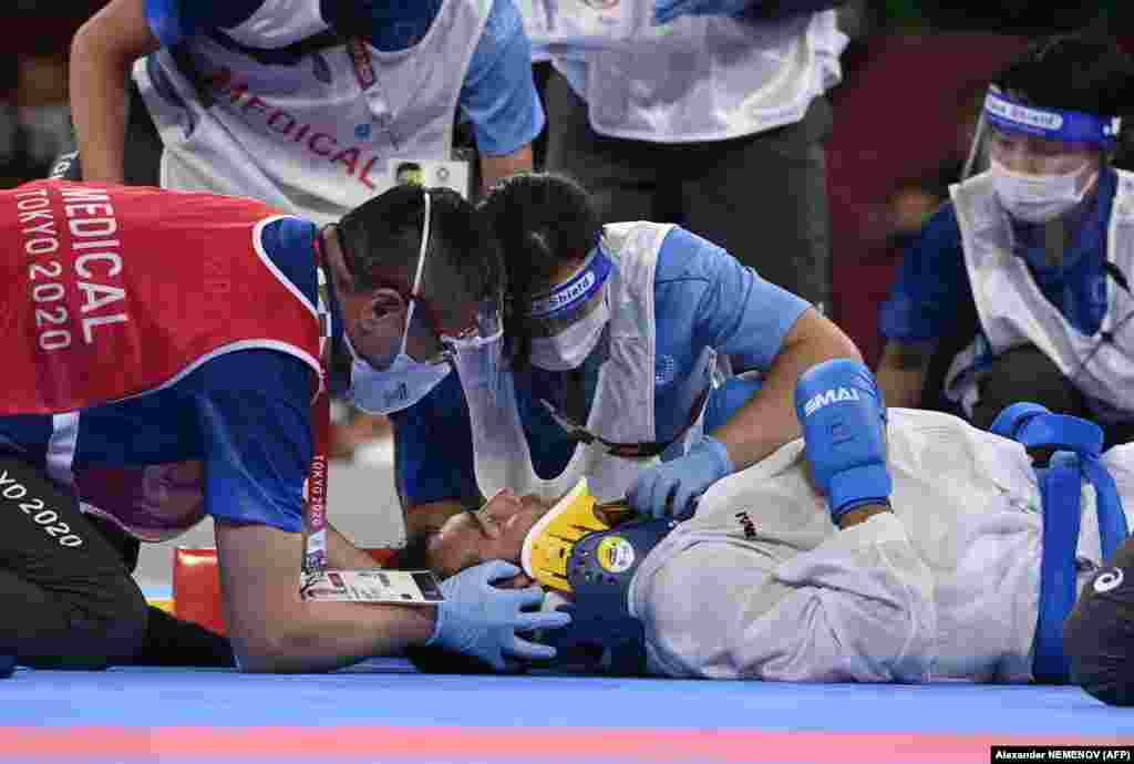 Иранец Саджад Ганджзаде осматривается медиками после травмы в финале соревнований по карате (кумите) свыше 75 кг против Тарега Хамеди из Саудовской Аравии во время Олимпийских игр 2020 года в Токио, 7 августа 2021 года