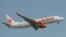 (FILES) This file photo taken on March 18, 2013 shows a Lion Air plane flying over Sukarno-Hatta airport in Tangerang, outside Jakarta. - An Indonesian Lion Air passenger plane went missing on October 29, 2018 shortly after taking off from the capital Jak
