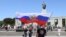 GERMANY -- A member of Russian motorcycle club Night Wolves carries a Russian flag as he walks towards the Soviet War Memorial in Berlin, May 9, 2018
