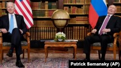 With a globe of the world in the background, U.S. President Joe Biden and Russian President Vladimir Putin meet for their June 16, 2021 summit at Villa La Grange in Geneva.
