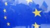 UKRAINE – Pro-European integration protesters are seen through an EU flag during a rally near the Interior Ministry headquarters in Kyiv December 17, 2013