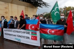 Turkish men in Istanbul hold a banner that reads "Karabakh is Azerbaijan. Azerbaijan is Turkey." during a September 29, 2020 protest against Armenia.