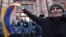 ARMENIA -- An opposition supporter waves an Armenian flag in front of law enforcement officers during a rally to demand the resignation of Prime Minister Nikol Pashinyan over a controversial peace deal with Azerbaijan that ended six weeks of war over the 