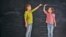 Generic -- Two children sisters play together. Kid measures the growth on the background of blackboard. Concept of education.