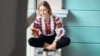 UKRAINE – Young beautiful girl student wearing a vyshyvanka, a traditional Ukrainian embroidered shirt checks her smartphone while drinking coffee between lectures