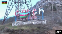 An image grab taken from a video made available on the official web site of the Azerbaijani Defense Ministry on November 9, 2020, shows an Azerbaijani flag hanging on a sign for the Karabakhi town of Shusha (Shushi in Armenian).