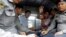 BURMA -- Detained Reuters journalist Wa Lone and Kyaw Soe Oo sit beside police officers as they leave Insein court in Yangon, Myanmar July 9, 2018