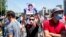 KYRGYZSTAN -- Gulshat Asylbekova - fake - Hundreds of Kyrgyz protest against a draft law they say will hit press and internet freedoms with a man holding up a portrait of MP, the bill initiator Gulshat Asylbayeva, Bishkek, June 29, 2020.