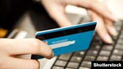 Czech republic. Internet shopping. Hands entering credit card information into a laptop. Shutterstock.
