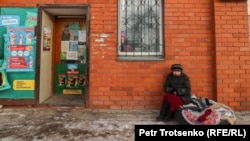 Женщина продает вязаные вещи около продуктового магазина. Петропавловск
