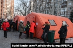 Передвижной пункт обогрева, где жители Киева могут согреться, выпить чаю, зарядить свои устройства и получить помощь во время отключений электроэнергии и отопления. Дарницкий район Киева, 14 января 2026